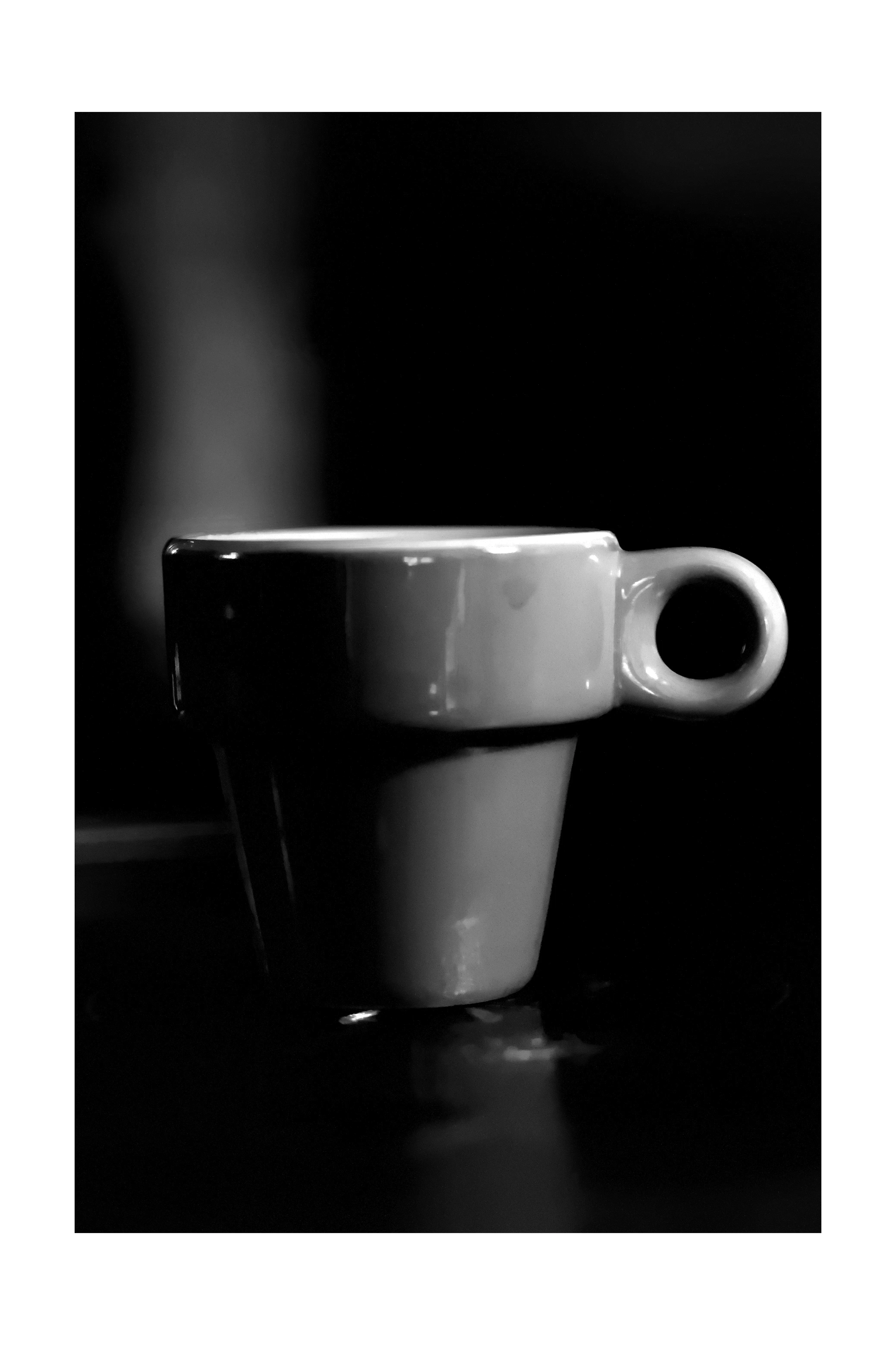 Tasse blanche isolée dans l'obscurité